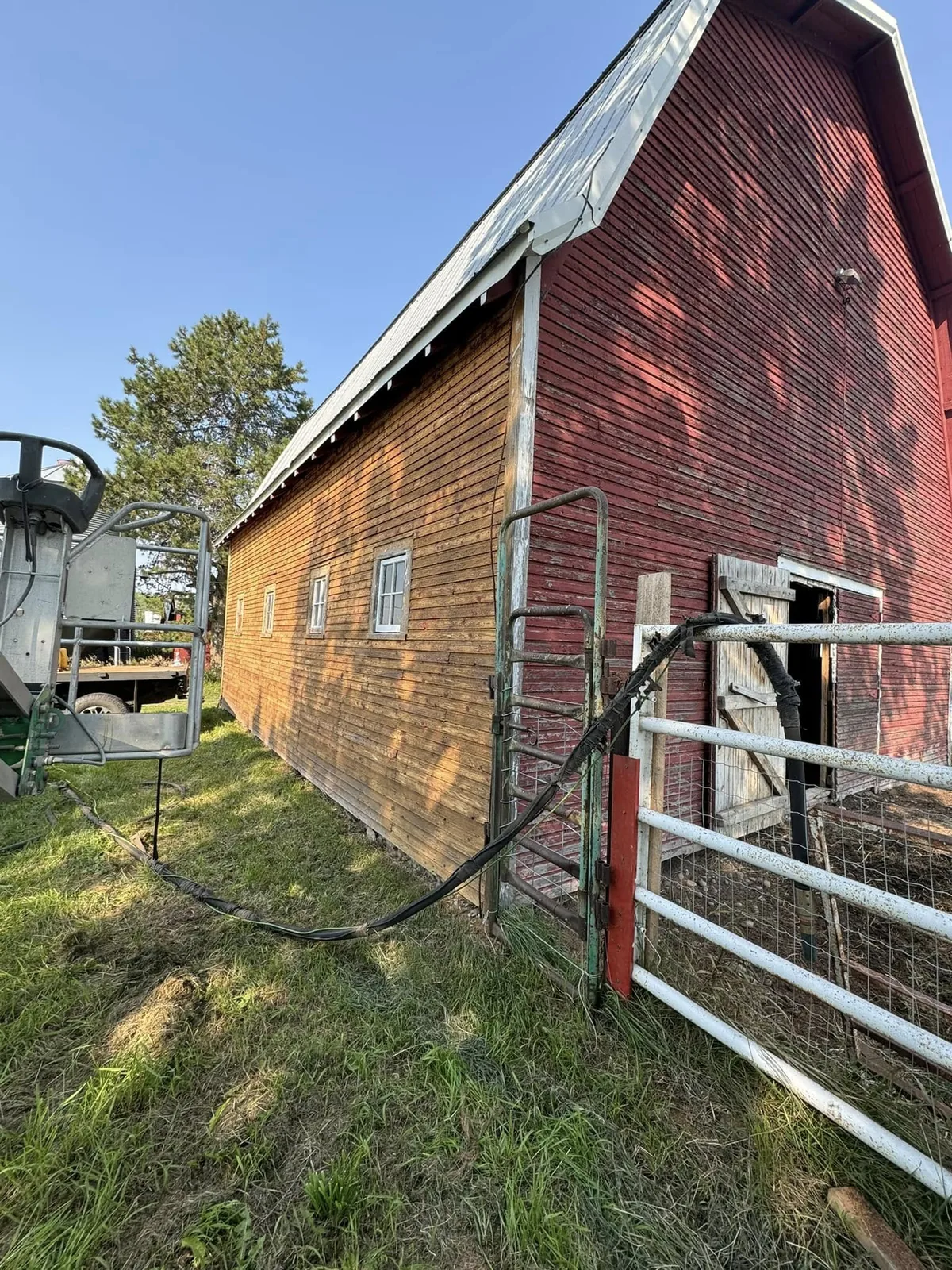Long barn wall partially stripped, showing gentle progress along thin heritage siding
