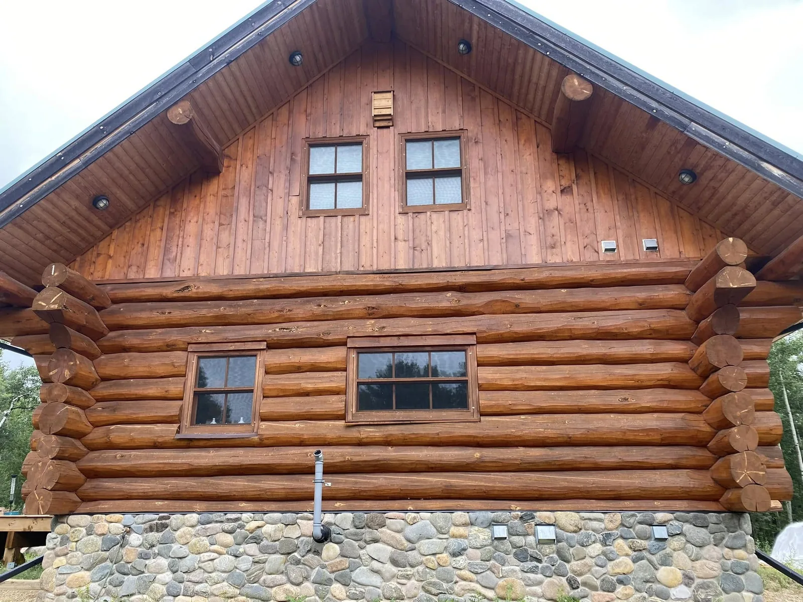 The same log home wall after restoration — blasted, cleaned and freshly stained