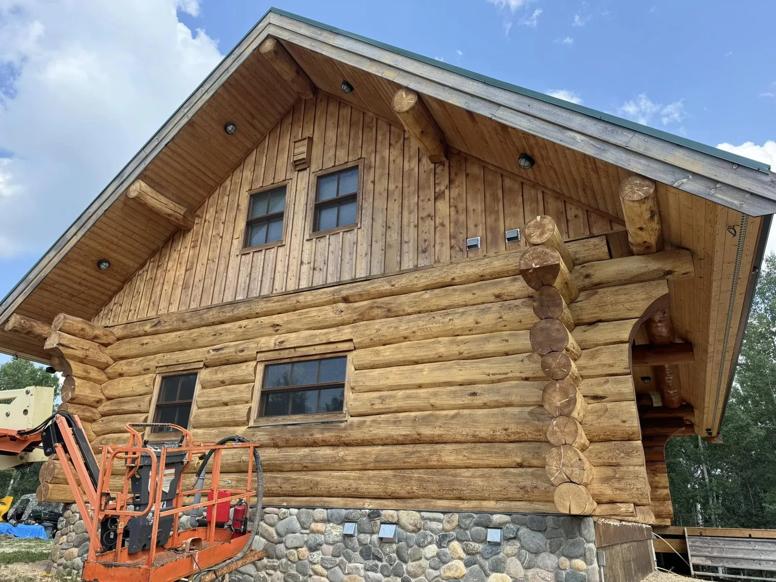 Alberta log home before restoration — weathered, UV-greyed logs